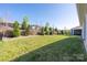 Spacious backyard with manicured lawn, fence, and tree-lined landscaping offers privacy and curb appeal at 6272 Raven Rock Dr, Denver, NC 28037