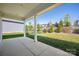 A covered patio offers views of the manicured lawn and tiered landscaping in the backyard at 6272 Raven Rock Dr, Denver, NC 28037