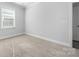 Bright bedroom with gray carpet, white walls, and a single window at 6272 Raven Rock Dr, Denver, NC 28037