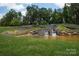 Scenic view of the Trilogy community entrance featuring a stone waterfall and well-maintained landscaping at 6272 Raven Rock Dr, Denver, NC 28037