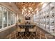 Elegantly lit wine room features a custom wine rack display, seating, and statement chandelier at 6272 Raven Rock Dr, Denver, NC 28037