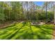 Expansive backyard with mature trees, a fire pit, and an outdoor dining area for entertaining at 7351 Bay Cove Ct, Denver, NC 28037