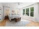 Bright bedroom with a wrought iron bed frame, wood floors, and large windows overlooking the surrounding trees at 7351 Bay Cove Ct, Denver, NC 28037