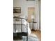 Close up of a cozy bedroom with a wrought iron bed frame, wood floors, and bamboo window shades at 7351 Bay Cove Ct, Denver, NC 28037
