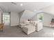 Bright bonus room features a plush white sectional sofa and neutral paint, creating a cozy space at 7351 Bay Cove Ct, Denver, NC 28037