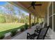 Inviting covered porch features rocking chairs, ceiling fans, and wooded views for outdoor relaxation at 7351 Bay Cove Ct, Denver, NC 28037