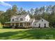 Charming two-story white farmhouse with a spacious front yard and inviting porch at 7351 Bay Cove Ct, Denver, NC 28037