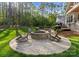 Outdoor fire pit with rocking chairs, creating a cozy gathering space in the lush backyard at 7351 Bay Cove Ct, Denver, NC 28037
