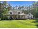 Charming front exterior of a white farmhouse, with a wide porch and lush green lawn at 7351 Bay Cove Ct, Denver, NC 28037