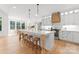 Bright kitchen features a large island with seating, stainless steel appliances, and custom wooden range hood at 7351 Bay Cove Ct, Denver, NC 28037