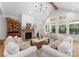 Bright living room features vaulted ceilings, brick fireplace, and large windows offering a view of nature at 7351 Bay Cove Ct, Denver, NC 28037