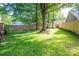 Expansive backyard featuring lush green grass, mature trees, and a wooden privacy fence at 741 Bermuda Ave, Gastonia, NC 28054
