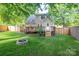 Private backyard with a wooden deck, fire pit, and surrounding privacy fence and lush lawn at 741 Bermuda Ave, Gastonia, NC 28054