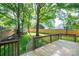 Lush backyard with a fire pit, mature trees, and a wooden fence, as seen from the back deck at 741 Bermuda Ave, Gastonia, NC 28054
