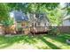 This backyard has a wooden deck, grass, trees and a partial fence for privacy at 741 Bermuda Ave, Gastonia, NC 28054