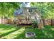 Backyard features a wooden deck, fire pit, green grass and a privacy fence, creating an outdoor space for relaxation at 741 Bermuda Ave, Gastonia, NC 28054
