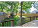 View from the wooden deck showcasing a lush backyard with a fire pit and mature trees at 741 Bermuda Ave, Gastonia, NC 28054