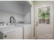 Laundry room featuring a washer and dryer, wire shelving, and exterior access door at 741 Bermuda Ave, Gastonia, NC 28054