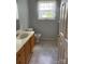 Bathroom features a toilet, sink with wood cabinets, shower, and a window at 7505 Conifer Cir, Indian Trail, NC 28079