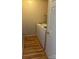 Laundry area has wood flooring and a white washer with wall and shelf at 7505 Conifer Cir, Indian Trail, NC 28079