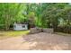 Backyard features a white storage shed, and a stone built in BBQ, and lots of mature trees at 7810 Trotter Rd, Charlotte, NC 28216