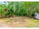 Backyard with mature trees, a blank canvas for your backyard ideas, and a storage shed in the corner at 7810 Trotter Rd, Charlotte, NC 28216