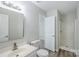 Bathroom featuring a single vanity, toilet, and glass door shower for a neat and functional space at 7810 Trotter Rd, Charlotte, NC 28216