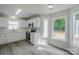 Cozy eat-in kitchen features white cabinets, stainless steel appliances, and charming breakfast nook at 7810 Trotter Rd, Charlotte, NC 28216