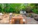 Outdoor dining area in backyard with spacious patio, stone grill, and ample seating at 7810 Trotter Rd, Charlotte, NC 28216
