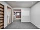 Partially finished basement with carpeted floors, exposed ceilings, and access to laundry and storage areas at 910 Surry Dr, Shelby, NC 28152