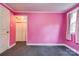 Spacious bedroom with bright pink walls, neutral carpeting, and a closet for ample storage at 910 Surry Dr, Shelby, NC 28152