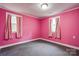 Bedroom features pink walls, neutral carpeting, and natural light coming through the windows at 910 Surry Dr, Shelby, NC 28152
