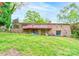Exterior brick home with a covered patio, deck, and green lawn with a gentle slope at 910 Surry Dr, Shelby, NC 28152