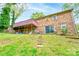 Exterior brick home featuring a deck, a covered patio, and a lush green lawn at 910 Surry Dr, Shelby, NC 28152