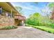 Low angle shot of the brick exterior of a home with a concrete patio and lush green lawn at 910 Surry Dr, Shelby, NC 28152
