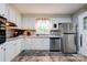 Bright kitchen featuring white cabinets, stainless steel appliances, and a window overlooking the yard at 910 Surry Dr, Shelby, NC 28152