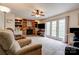Cozy living room features a brick fireplace, built-in shelves, a ceiling fan, and sliding doors to a balcony at 910 Surry Dr, Shelby, NC 28152