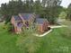 Aerial view of a brick home with a well-manicured lawn, mature trees, and a long driveway at 914 Olive Mill Ln, Matthews, NC 28104