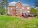 Rear exterior of a brick home with a wooden deck and well-manicured lawn at 914 Olive Mill Ln, Matthews, NC 28104