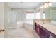Neutral bathroom features a shower, a large tub, wood cabinets, and a framed mirror at 914 Olive Mill Ln, Matthews, NC 28104