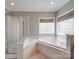 Bright bathroom features a large tub, separate shower with glass doors, and a window allowing natural light at 914 Olive Mill Ln, Matthews, NC 28104