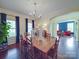 Bright dining room featuring hardwood floors, a chandelier, and natural light from the two large windows at 914 Olive Mill Ln, Matthews, NC 28104