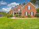 Charming two-story brick home featuring manicured landscaping and an inviting front porch at 914 Olive Mill Ln, Matthews, NC 28104