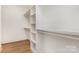 Walk-in closet with built-in shelving and hardwood floors at 933 Tennyson Dr, Charlotte, NC 28208