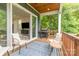 A cozy covered deck features comfortable seating and a grill with backyard views at 933 Tennyson Dr, Charlotte, NC 28208