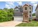 Charming two-story home with a two-car garage, lush landscaping, and a mix of modern siding materials at 933 Tennyson Dr, Charlotte, NC 28208