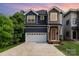 Charming two-story home with a two-car garage, lush landscaping, and a mix of modern siding materials at 933 Tennyson Dr, Charlotte, NC 28208