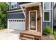 The front porch has a modern wood door with glass, side-light windows and a two-car garage at 933 Tennyson Dr, Charlotte, NC 28208