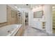 Bright bathroom featuring a soaking tub, glass shower, and a vanity with ample storage space at 10101 Bayart Way, Huntersville, NC 28078