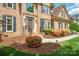 Close-up of home's entrance showcasing brick facade, landscaping, and a well-maintained front walkway and lawn at 10101 Bayart Way, Huntersville, NC 28078